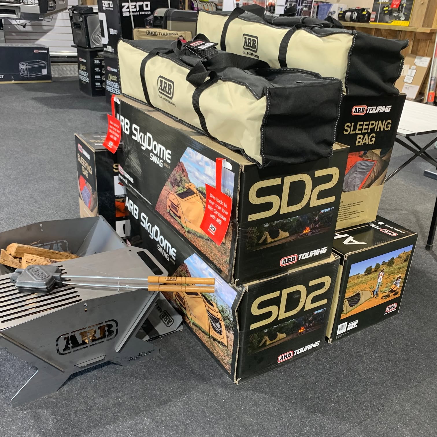 ARB Touring swags, sleeping bags and a fire pit set up in the shop